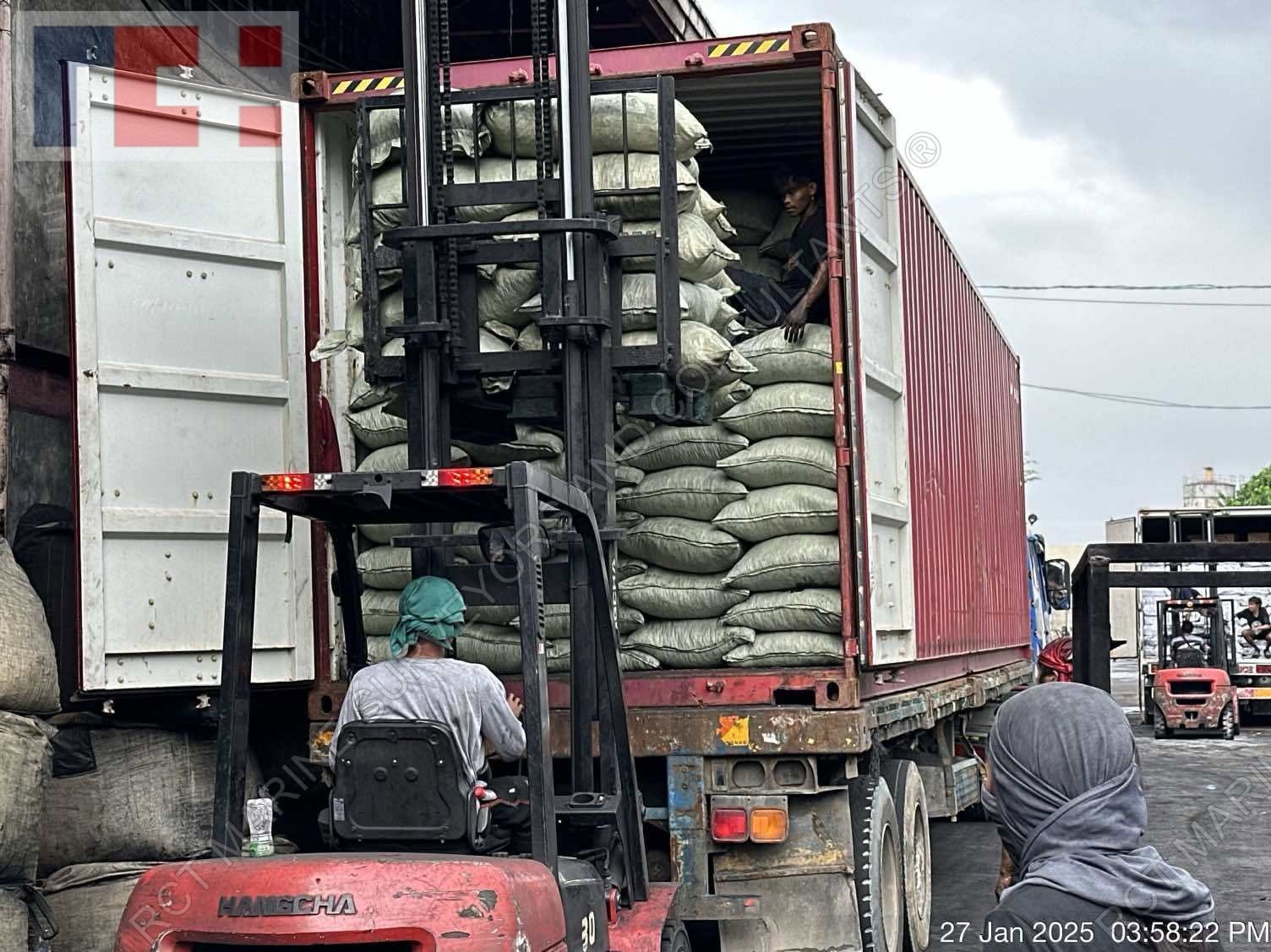 Forklift loading bagged cargo into container truck
